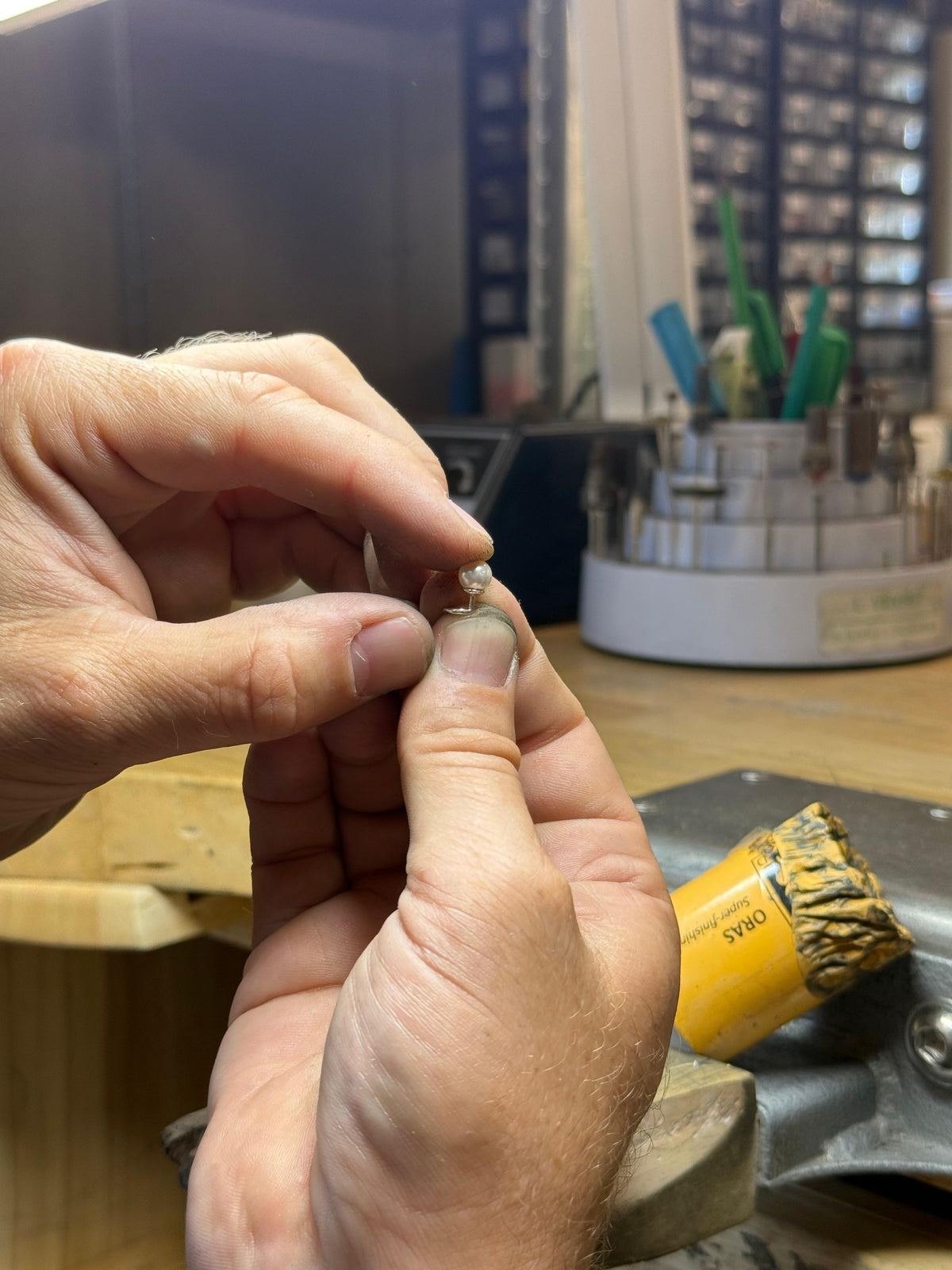 Photo de deux mains portant une boucle d'oreille sans fermoir Sofia de chez Sédonia